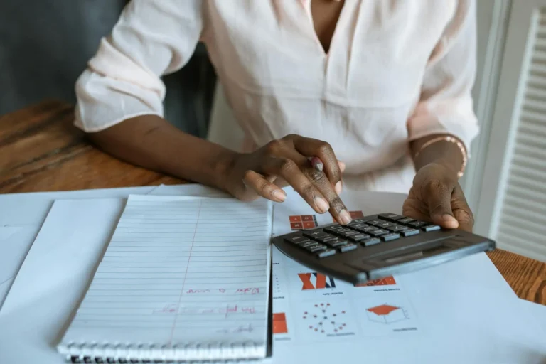 Engenheira utilizando uma calculadora para obter o custo de um serviço.